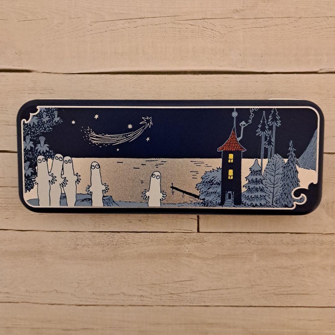 Closed MOOMIN x Mary’s Nyoro-nyoro rectangular metal pen case showing a blue night-scene illustration with Nyoro-nyoro characters on the lid.