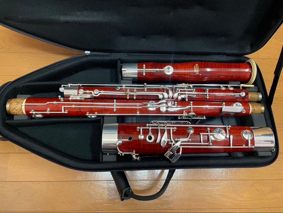 Disassembled Moosmann bassoon (fagott) in its black case showing wooden sections and silver keys.