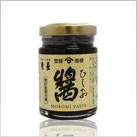 A glass jar of moromi paste with a Japanese label and a gold lid.