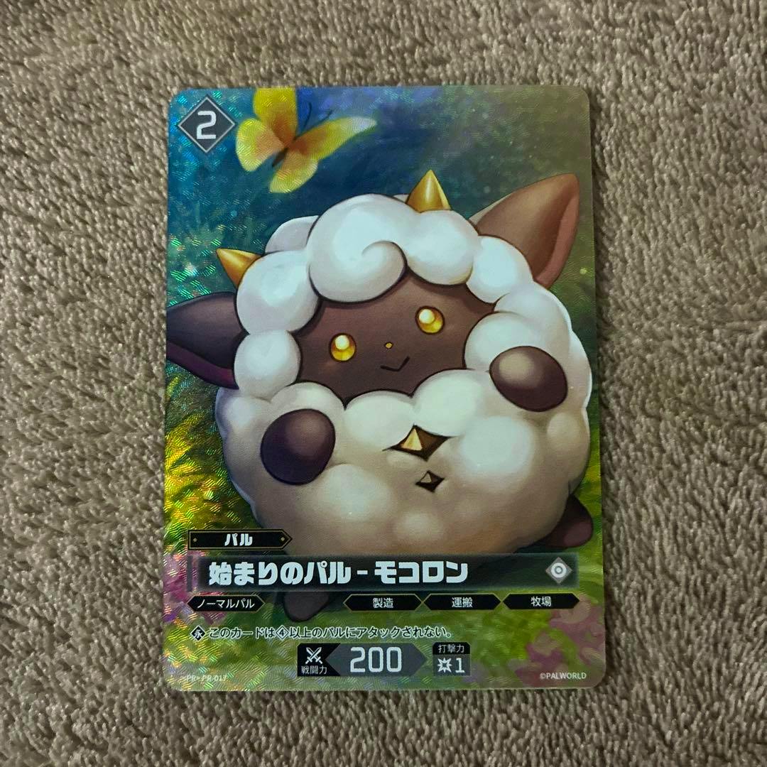 Photo of the front of the trading card '始まりのパル - モコロン' showing the illustrated fluffy creature artwork and Japanese card text.