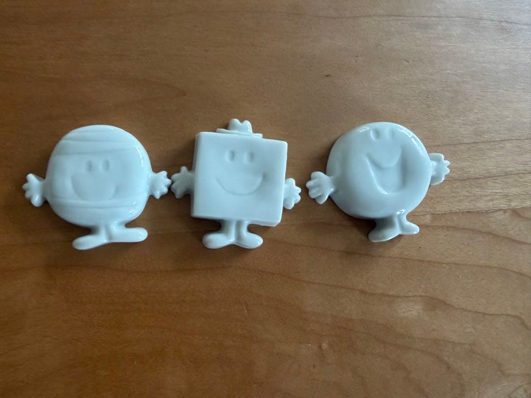 Three white ceramic Mr. Men/Little Miss chopstick rests shown front-side on a wooden surface.