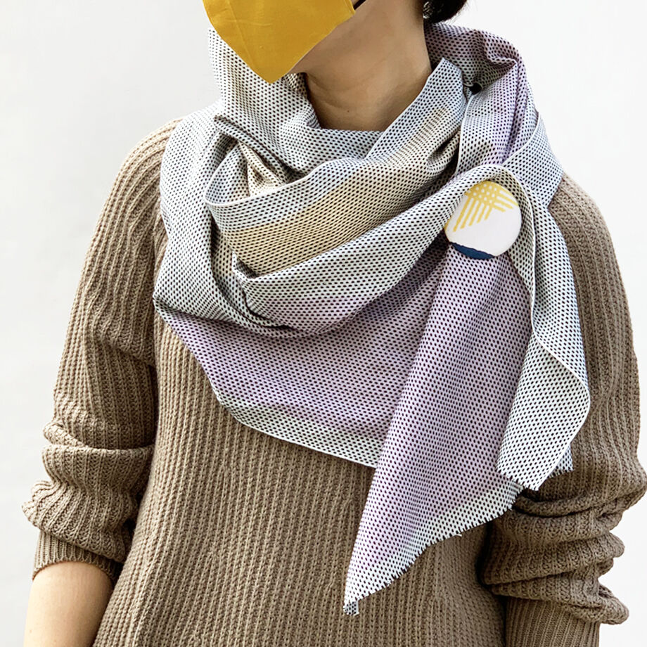 A person wearing the sashiko-style cotton tenugui scarf wrapped around their neck.
