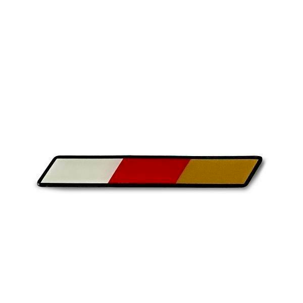 Photo of the MUGEN tricolor potting car emblem showing white, red, and gold diagonal sections in a narrow slanted rectangular badge.