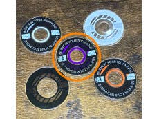 Several circular joystick lever disks and rings in various colors arranged on a wooden surface.