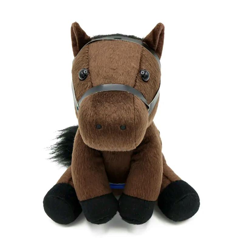 Front view of a brown plush horse toy with black hooves, a black mane, a black bridle, and a blue strap, sitting on a white background.