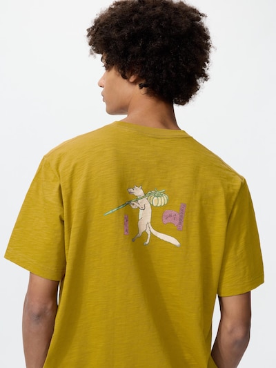 Back view of a male model wearing a mustard-colored men's cotton T-shirt with a small printed ukiyo-e style illustration on the upper back.