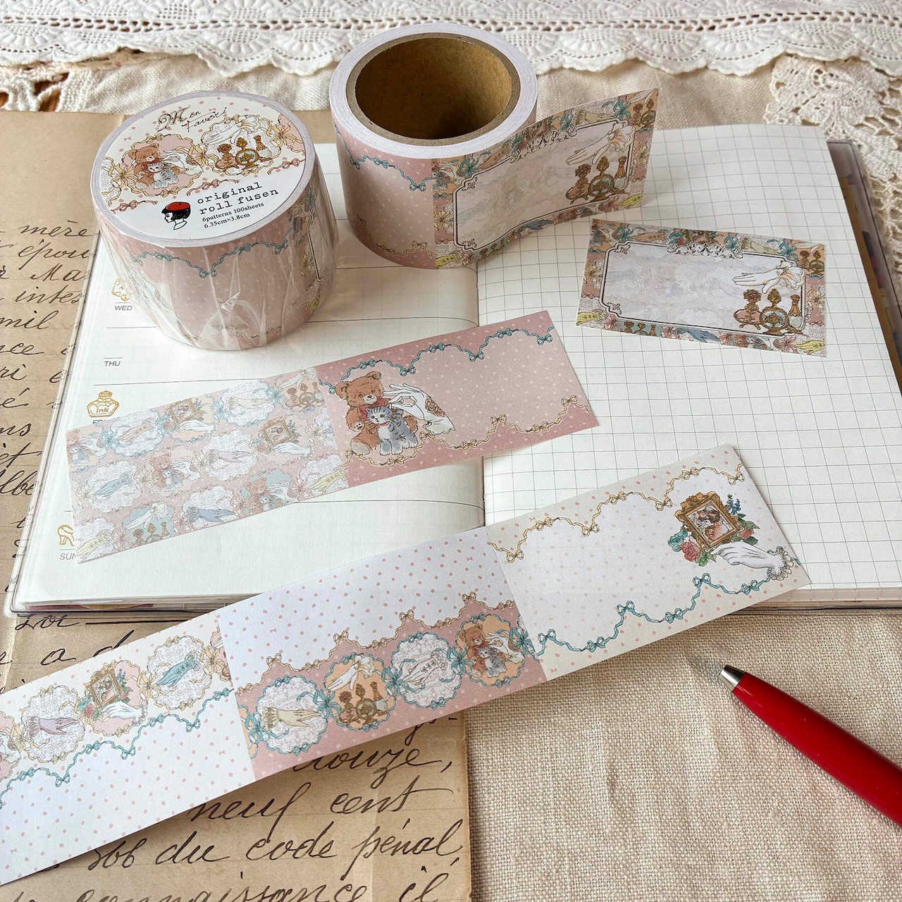 Pink roll sticky notes with bear and floral illustrations shown unrolled on a notebook.