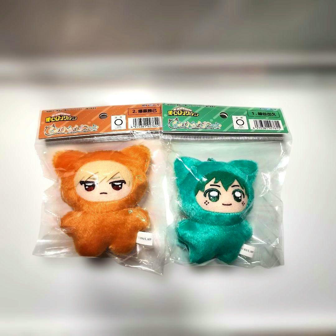 Two sealed My Hero Academia ちみけもますこっと plush toys of 爆豪勝己 (orange) and 緑谷出久 (green) shown in plastic packaging.