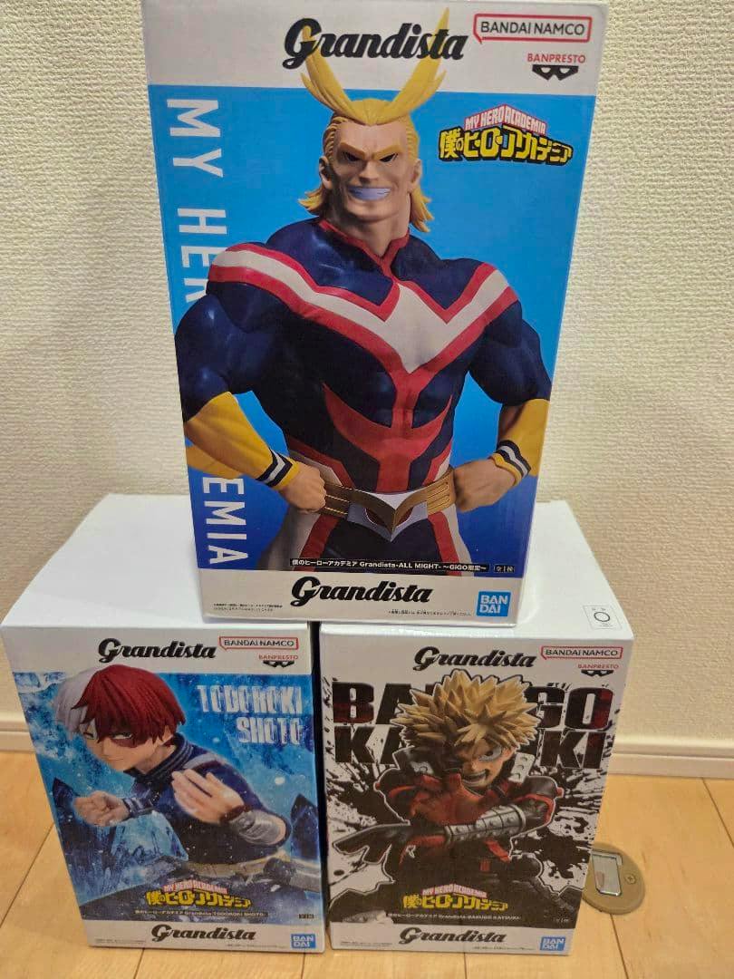 Three Grandista My Hero Academia figure product boxes with character artwork stacked together on a floor against a wall.