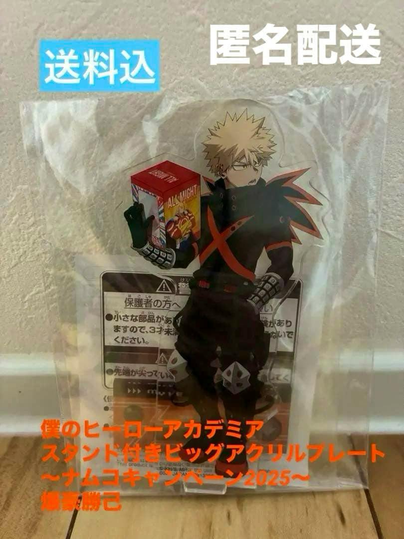 Packaged acrylic decorative stand of Bakugo Katsuki (My Hero Academia) showing the printed front artwork of the character holding a small box.