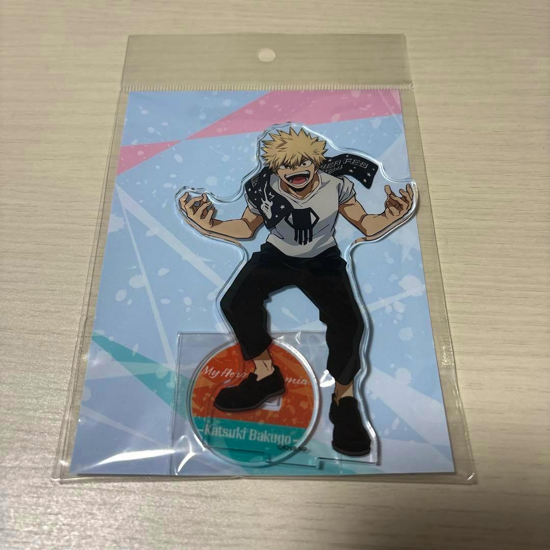 Packaged acrylic stand of Katsuki Bakugo from My Hero Academia shown in a plastic sleeve with illustrated backing card.