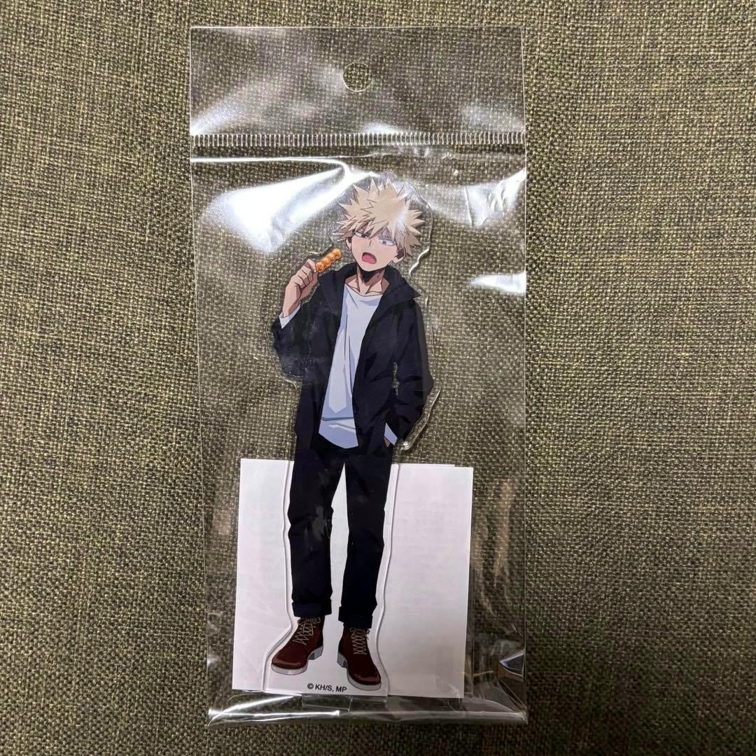 A packaged acrylic stand of Bakugo Katsuki (My Hero Academia) inside a clear plastic bag placed on a fabric surface.