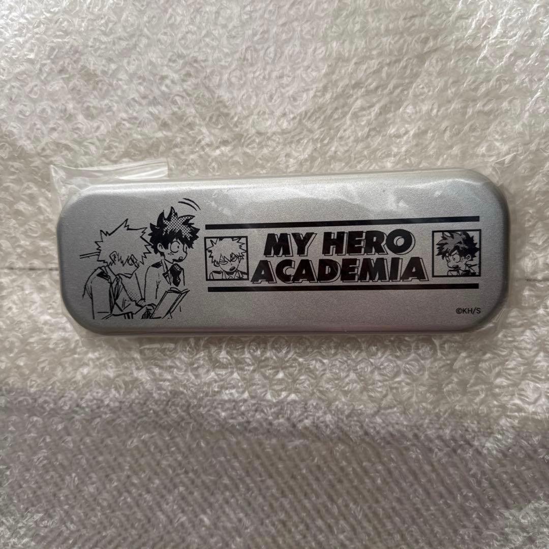 Silver tin pen case showing the 'MY HERO ACADEMIA' logo and two characters printed on the lid.