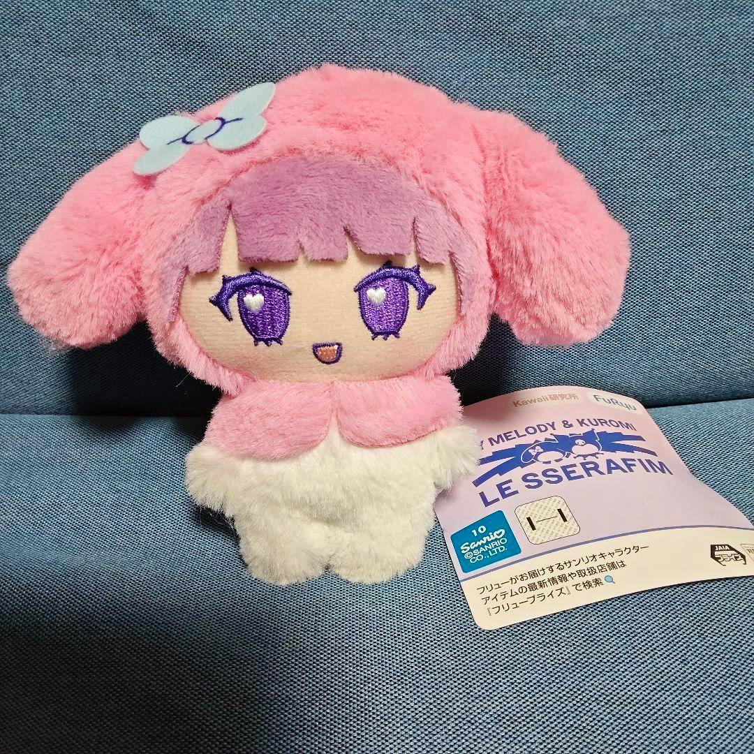 Front view of a pink MY MELODY × LE SSERAFIM Chewon costume plush toy with an embroidered face and an attached product tag.