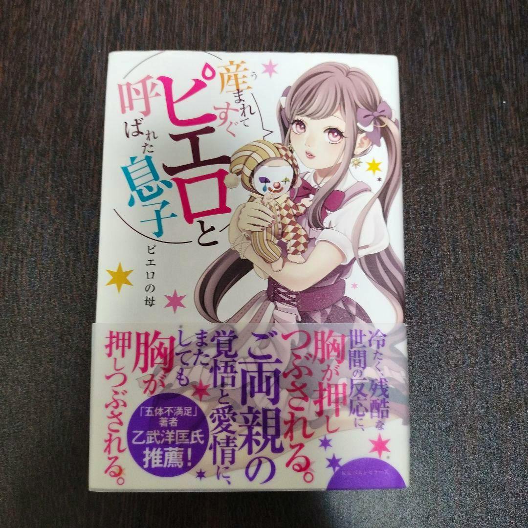 Front cover of the book '産まれてすぐピエロと呼ばれた息子' showing an illustrated girl holding a clown doll and Japanese title text.