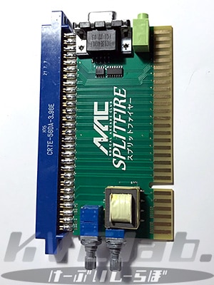 A green JAMMA controller board labeled "NAC SPLITFIRE" showing a gold edge connector, a blue multi-pin connector, and audio/video terminals.