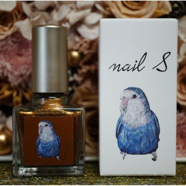 Glass bottle of the nail product with a metallic cap displayed next to its illustrated box.