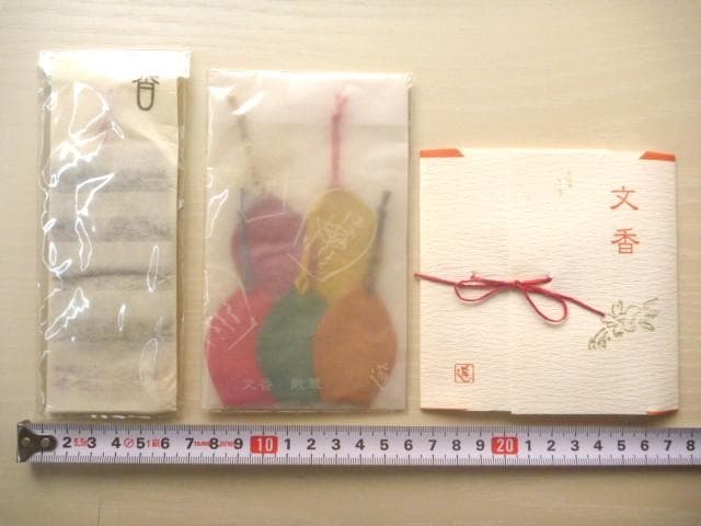 Three packaged fumikō (scented letter bookmarks) displayed with a measuring tape on a light surface.