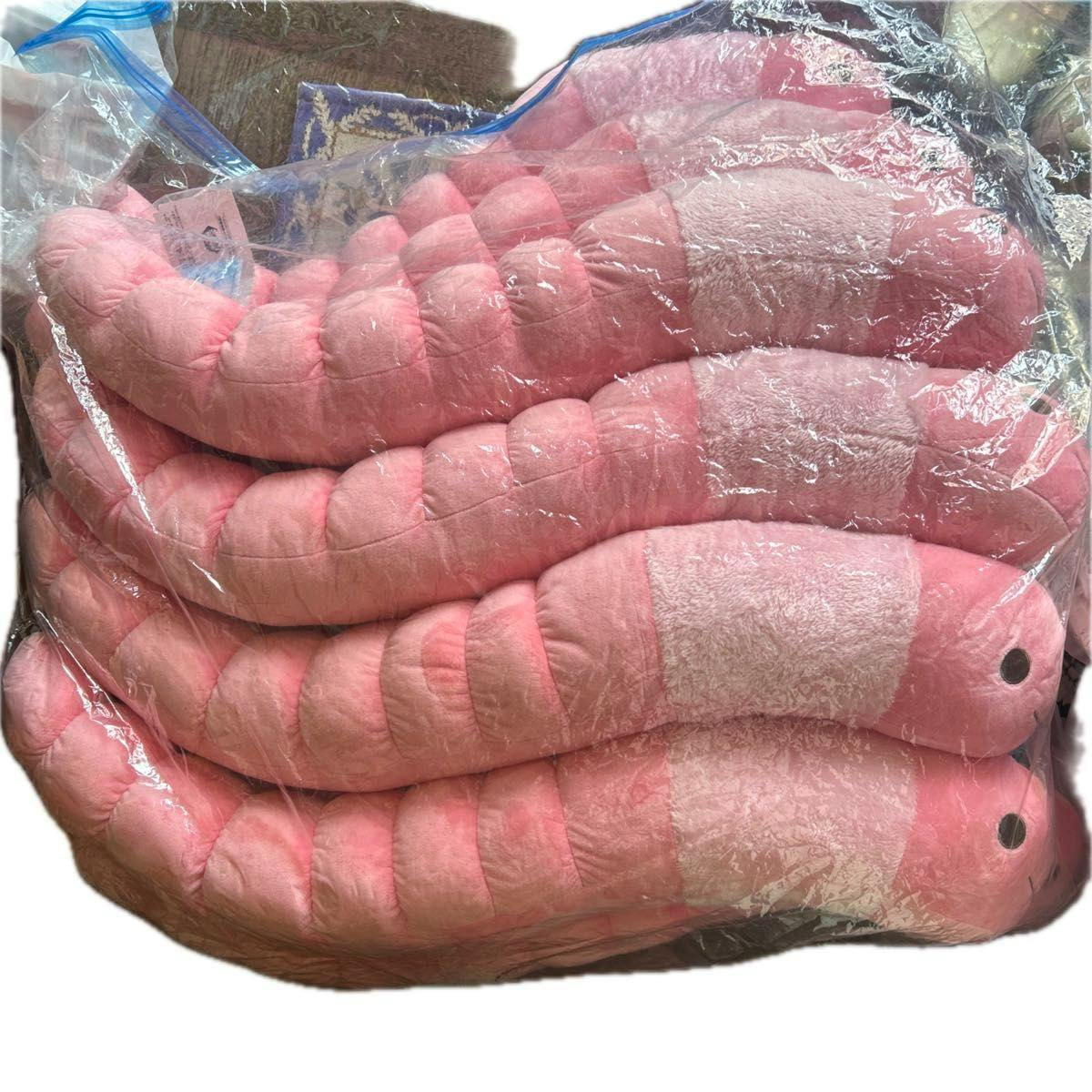 Pink worm plush toys stacked and wrapped in a clear plastic bag.
