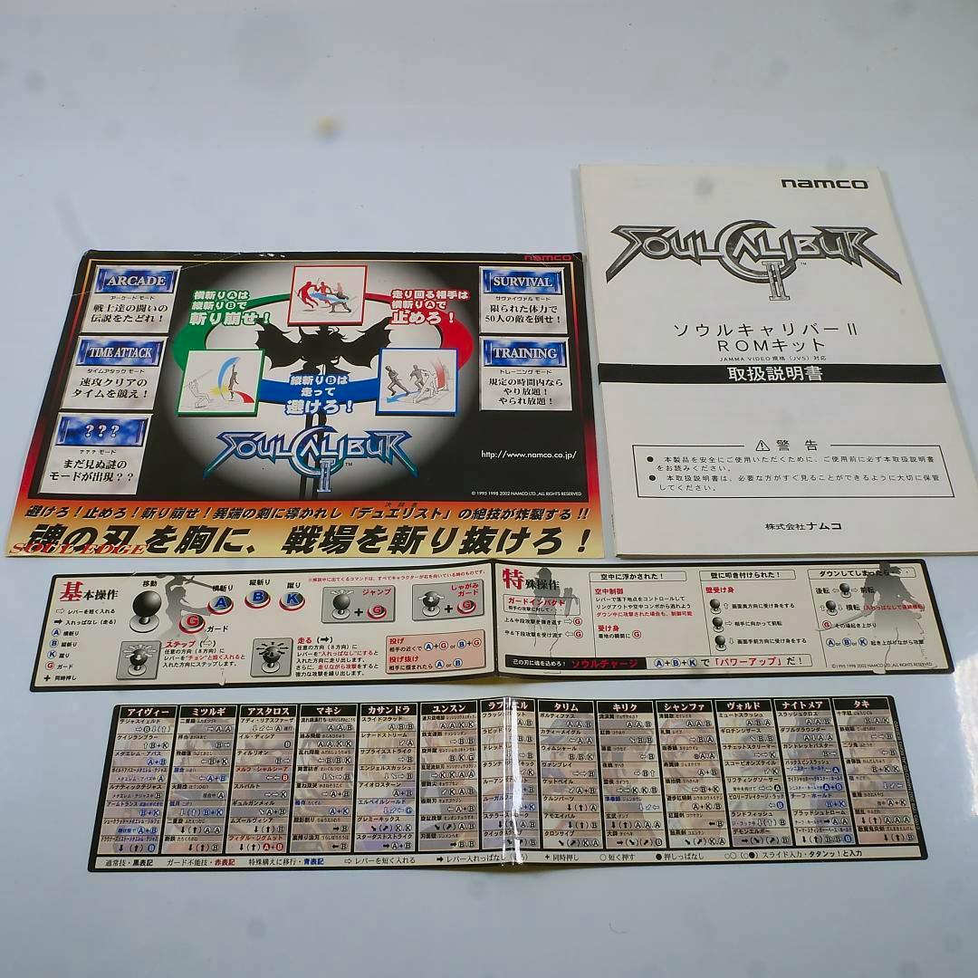 A Soul Calibur II instruction poster and Japanese instruction manual laid flat alongside a fold-out control chart.