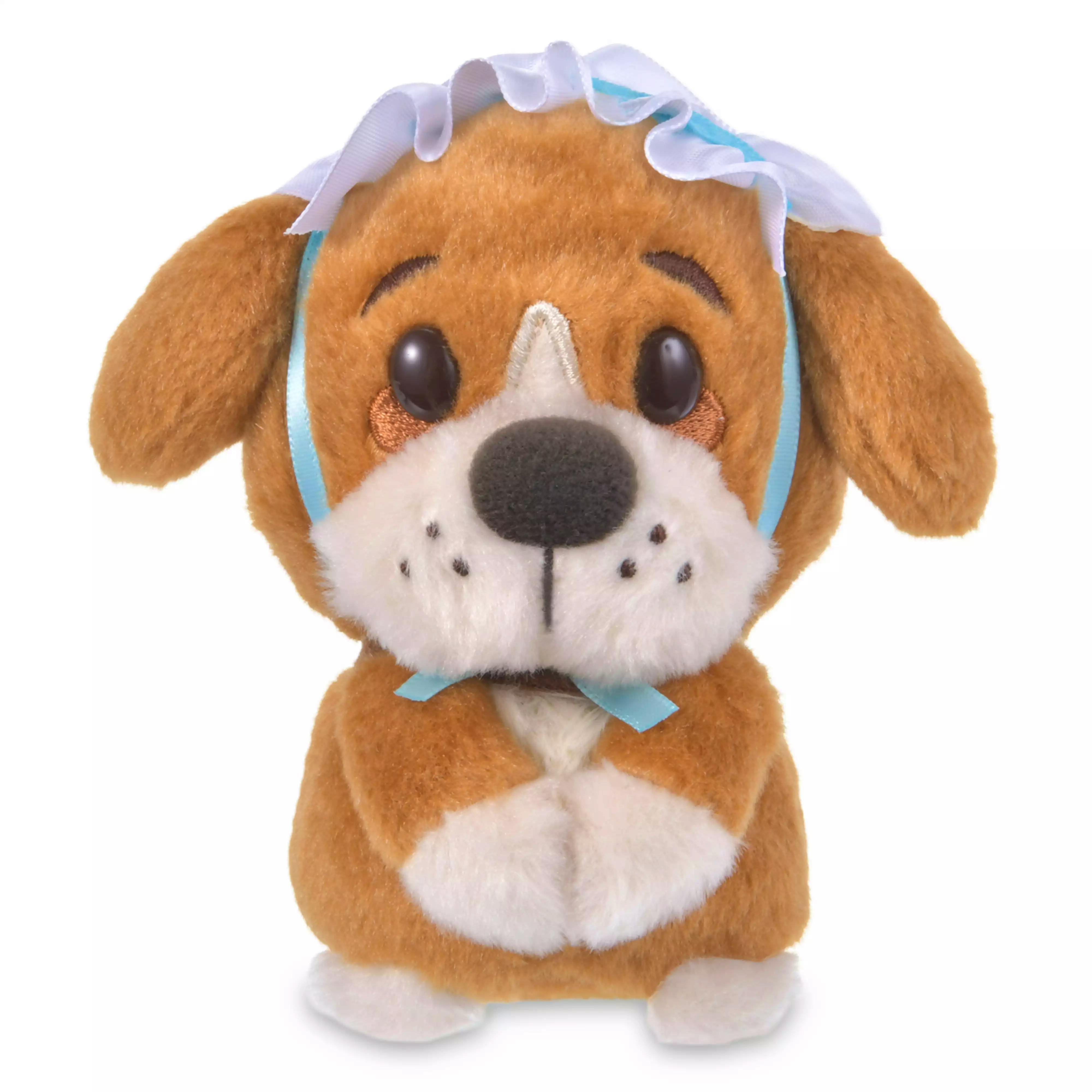 Front view of a brown-and-white plush toy dog wearing a blue ribbon and a white frilly bonnet.