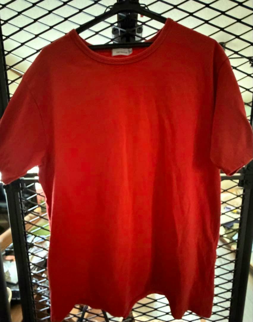 Red T-shirt hanging on a black hanger showing the front of the garment.