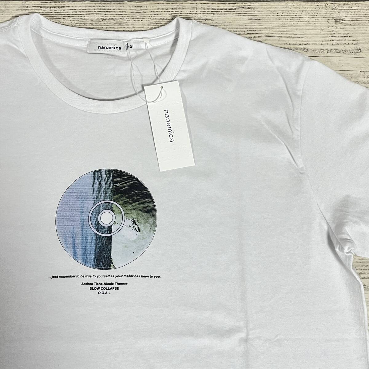 White nanamica graphic cotton T-shirt (size M) showing a circular front print and an attached retail tag.