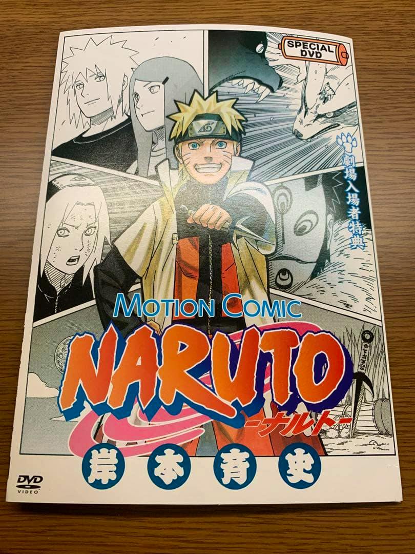 Photograph of the Naruto Motion Comic DVD cover insert showing Naruto and other characters on a wooden surface.