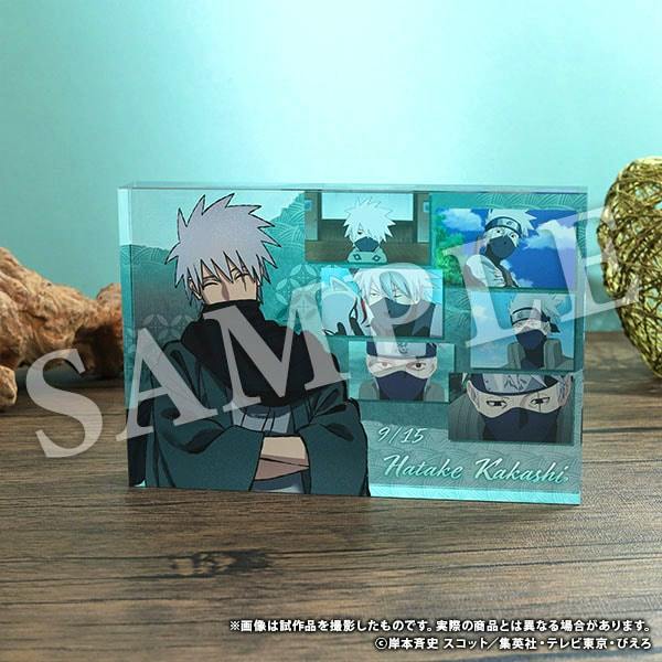 Photograph of an acrylic block featuring multiple-panel illustrations of Hatake Kakashi displayed on a wooden surface.
