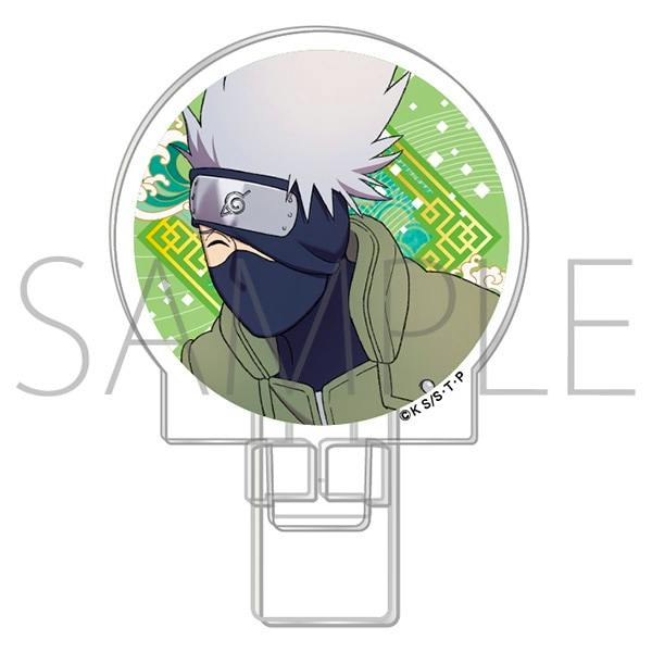 Circular acrylic clip stand featuring a head-and-shoulders illustration of Kakashi on a green patterned background with the attached clip visible.