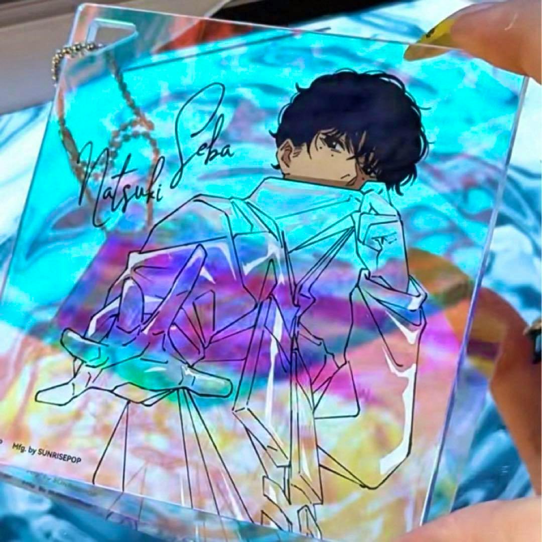 Hand-held holographic acrylic coaster showing a line-art illustration of Natsuki Seba with rainbow optical-camouflage reflections.