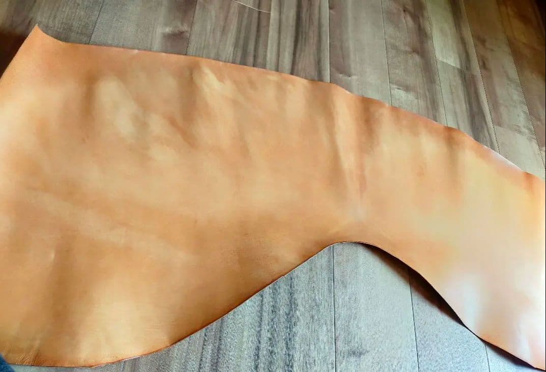 Natural-colored horse leather (cordovan) hide laid flat on a wooden floor.