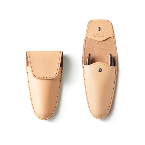 Two natural-colored cow leather key cases shown side by side, one closed and the other open showing its interior and a metal object inside.
