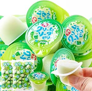 Multiple small green plastic cups of melon cream soda jelly, with one cup opened to show the jelly and a hand peeling back the lid.