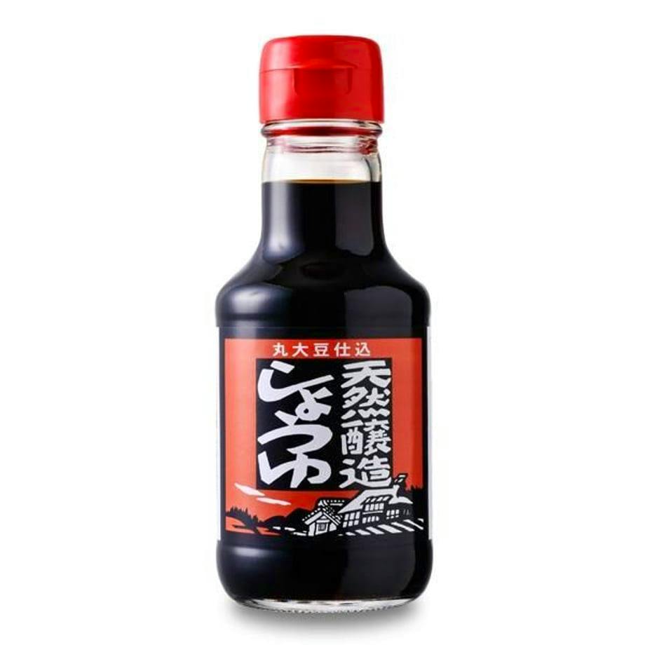 A bottle of 丸大豆仕込天然醸造醤油 with a red cap and a red-and-black label showing Japanese text.