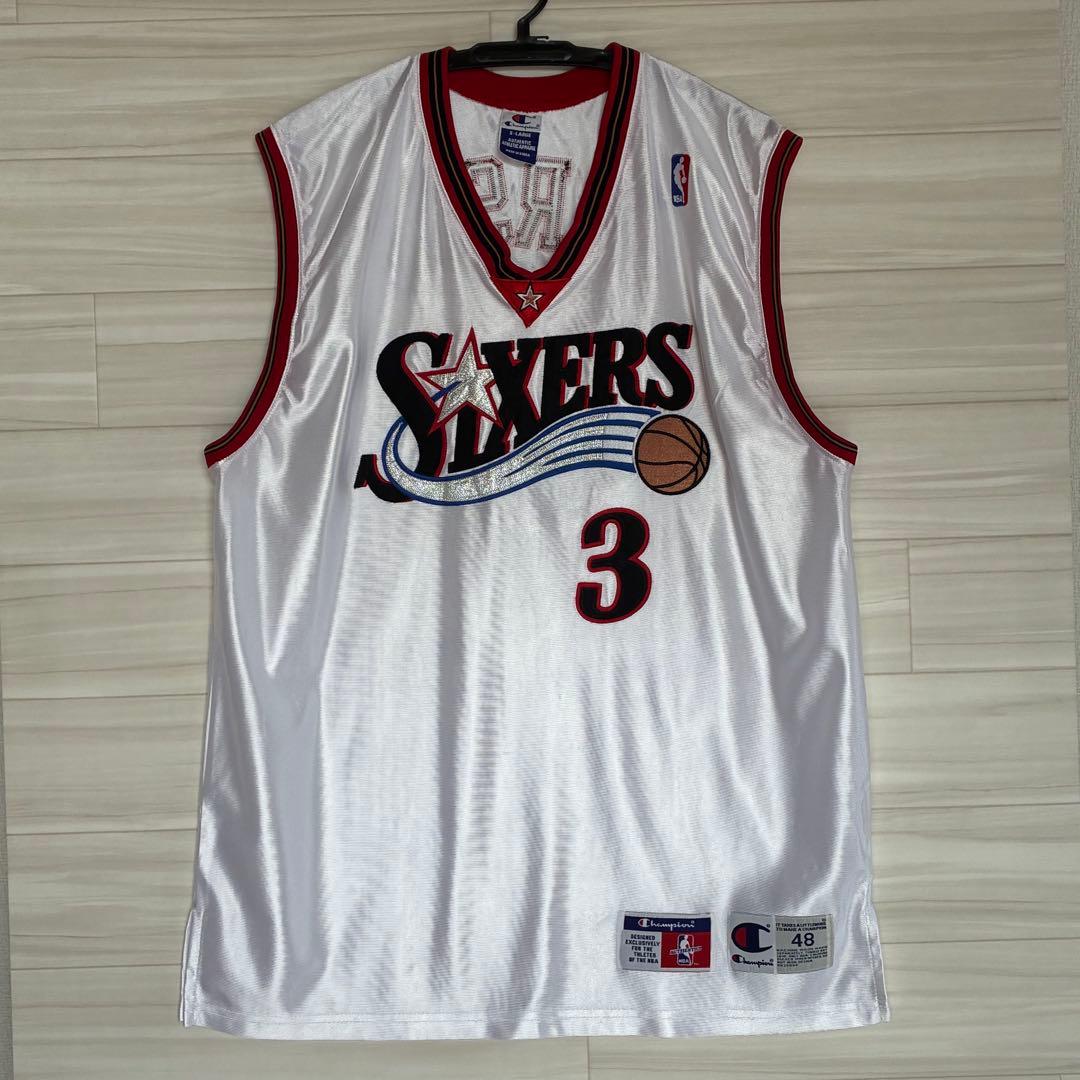 Front view of a white Philadelphia 76ers Allen Iverson basketball jersey (number 3) size 48 laid flat on a light wood floor.