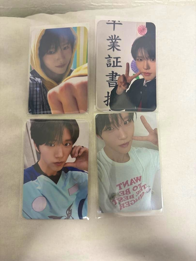 Four NCT WISH photocard prints in plastic sleeves arranged in two columns on a light surface.