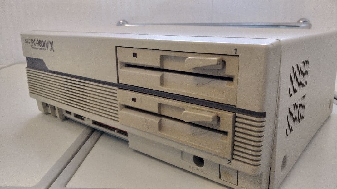 Front view of the PC-9801VX21 main unit showing two floppy disk drives and a ventilation grille.