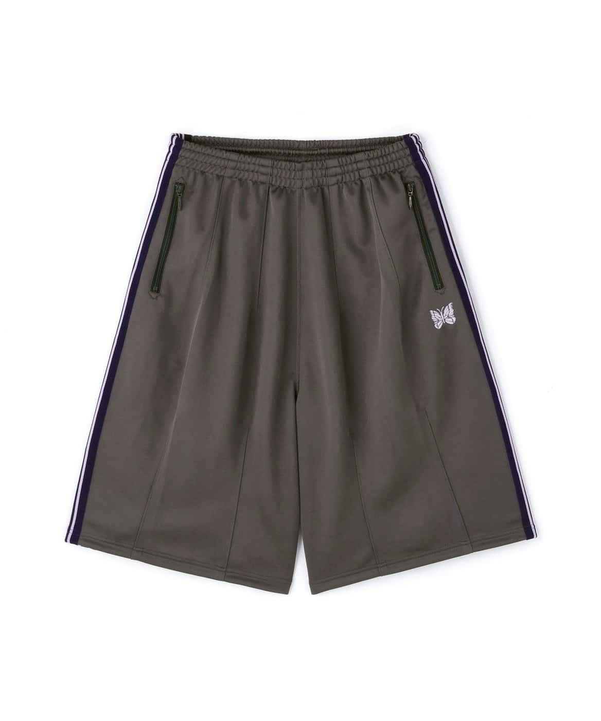 Charcoal Needles track shorts laid flat on a white background, showing an elastic waistband, zip pockets, side stripes, and an embroidered butterfly logo.
