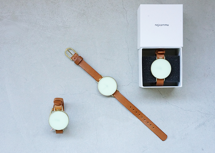 Flat-lay showing nejicommu × Palm maison DAY AND NIGHT XL watches with yellow faces and brown leather straps, two displayed and one in an open box on a gray surface.