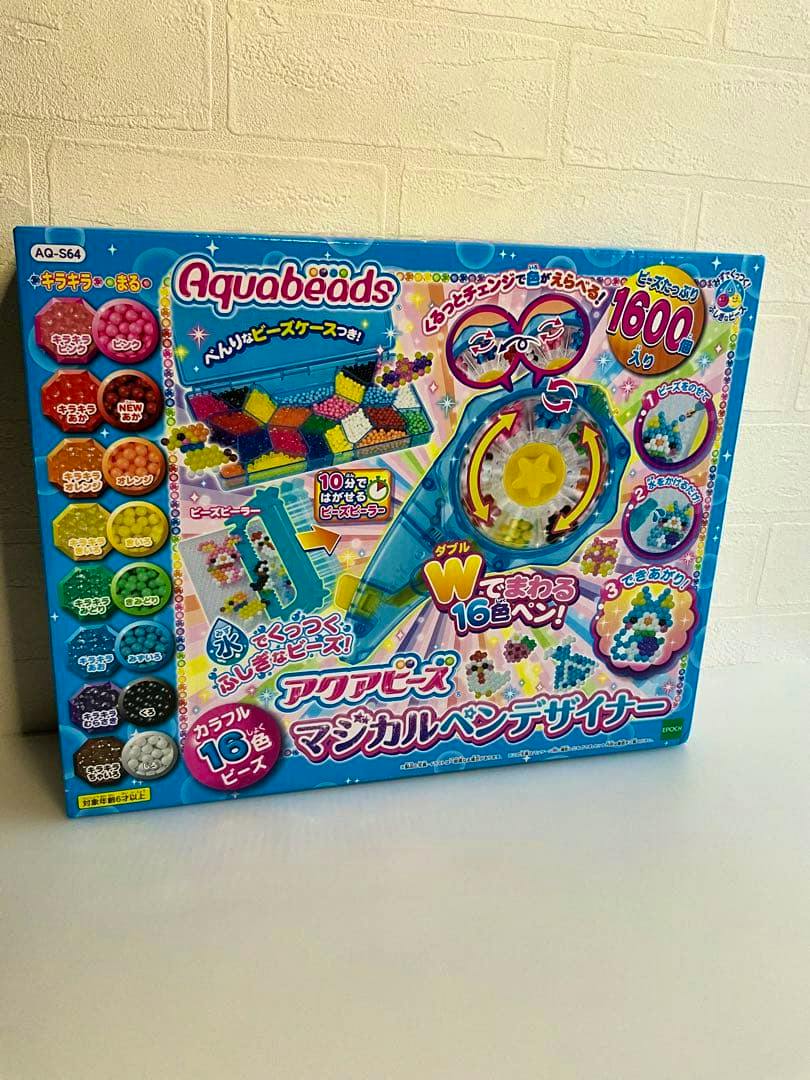 Box of the Aquabeads Magical Pen Designer toy set shown standing against a white wall.