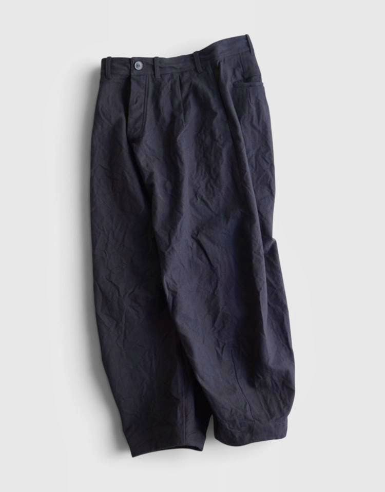 Womens baggy woven trousers laid flat on a light background.