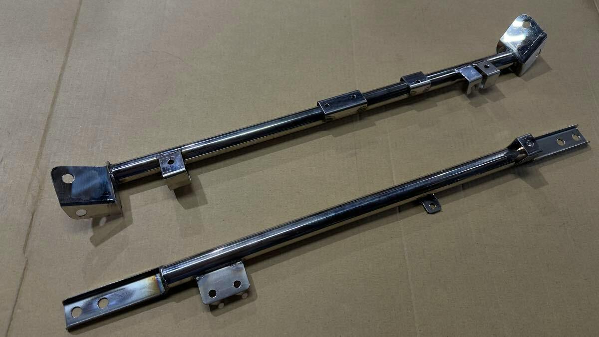 Two metal bars from a Cappuccino front cross member and upper sub-member set laid flat on cardboard.