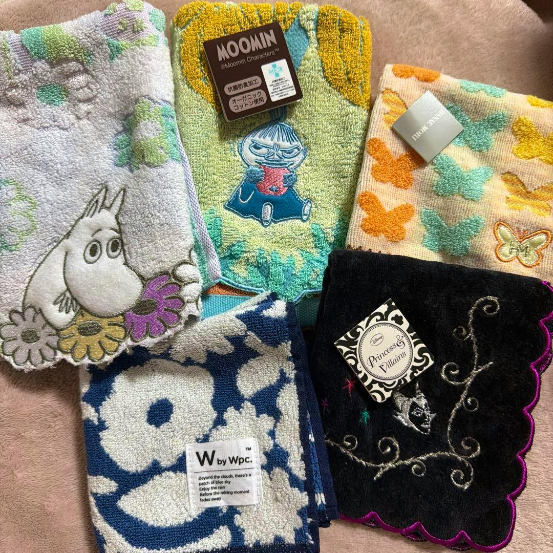 Five patterned handkerchiefs arranged together, including Moomin designs and a W by Wpc. label.