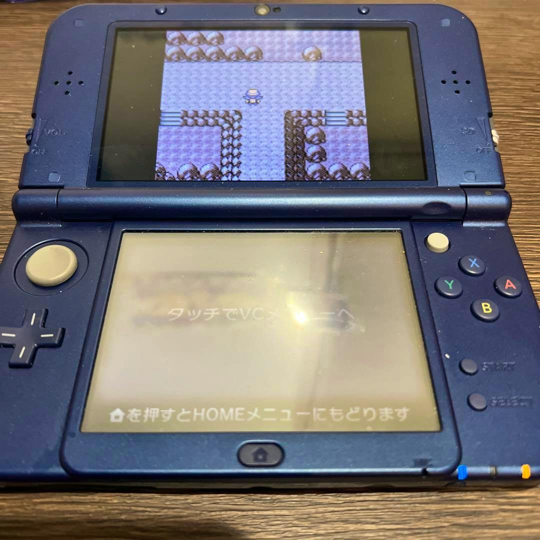 An open New Nintendo 3DS LL in metallic blue showing the top and bottom screens and the control buttons.