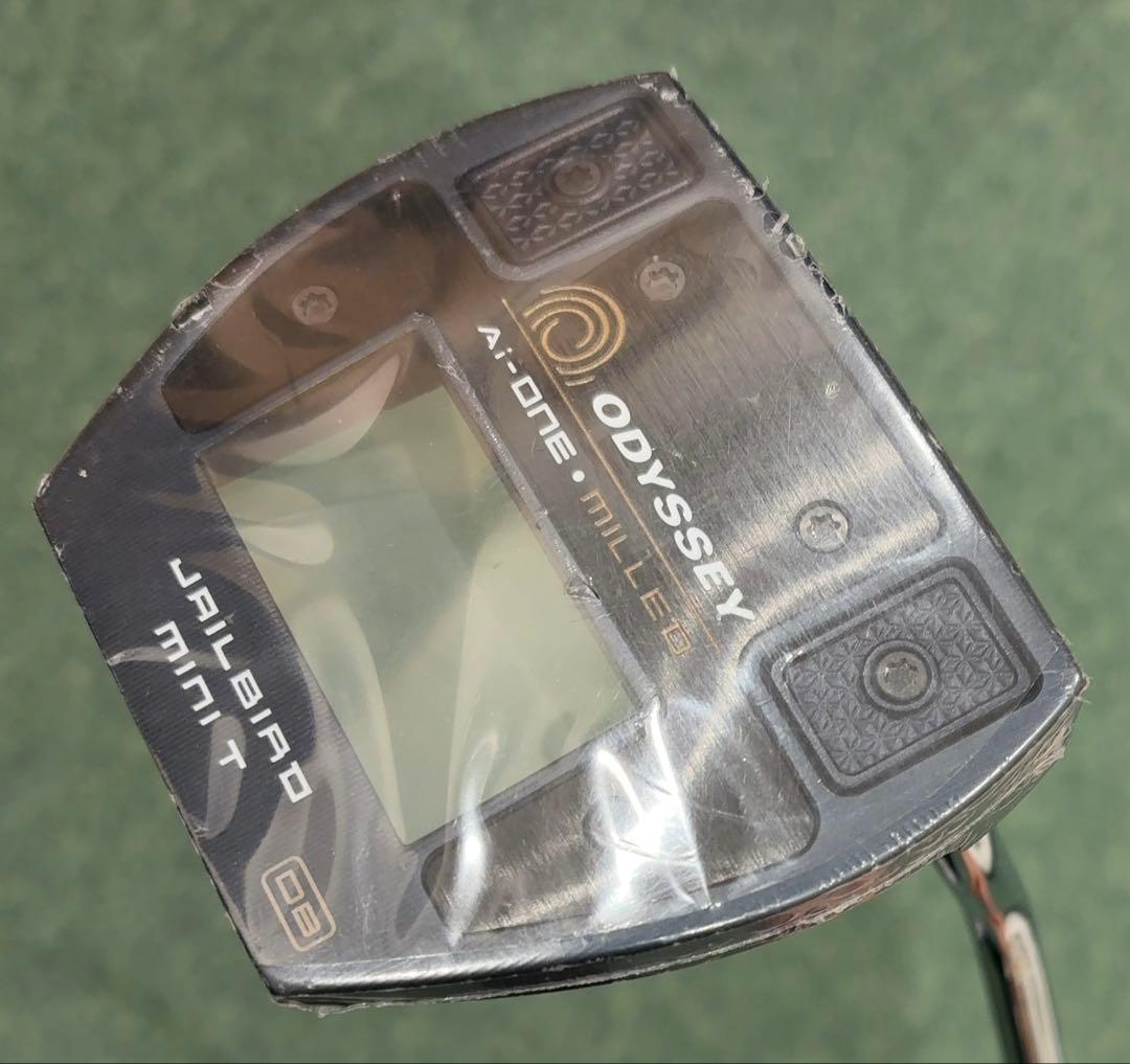 Close-up photo of the Odyssey Ai-ONE MILLED Jailbird putter head with protective plastic film covering.
