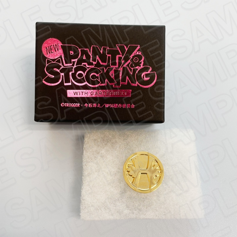 A gold round medal displayed on white padding next to a black box printed with “NEW PANTY & STOCKING WITH GARTERBELT” in pink.