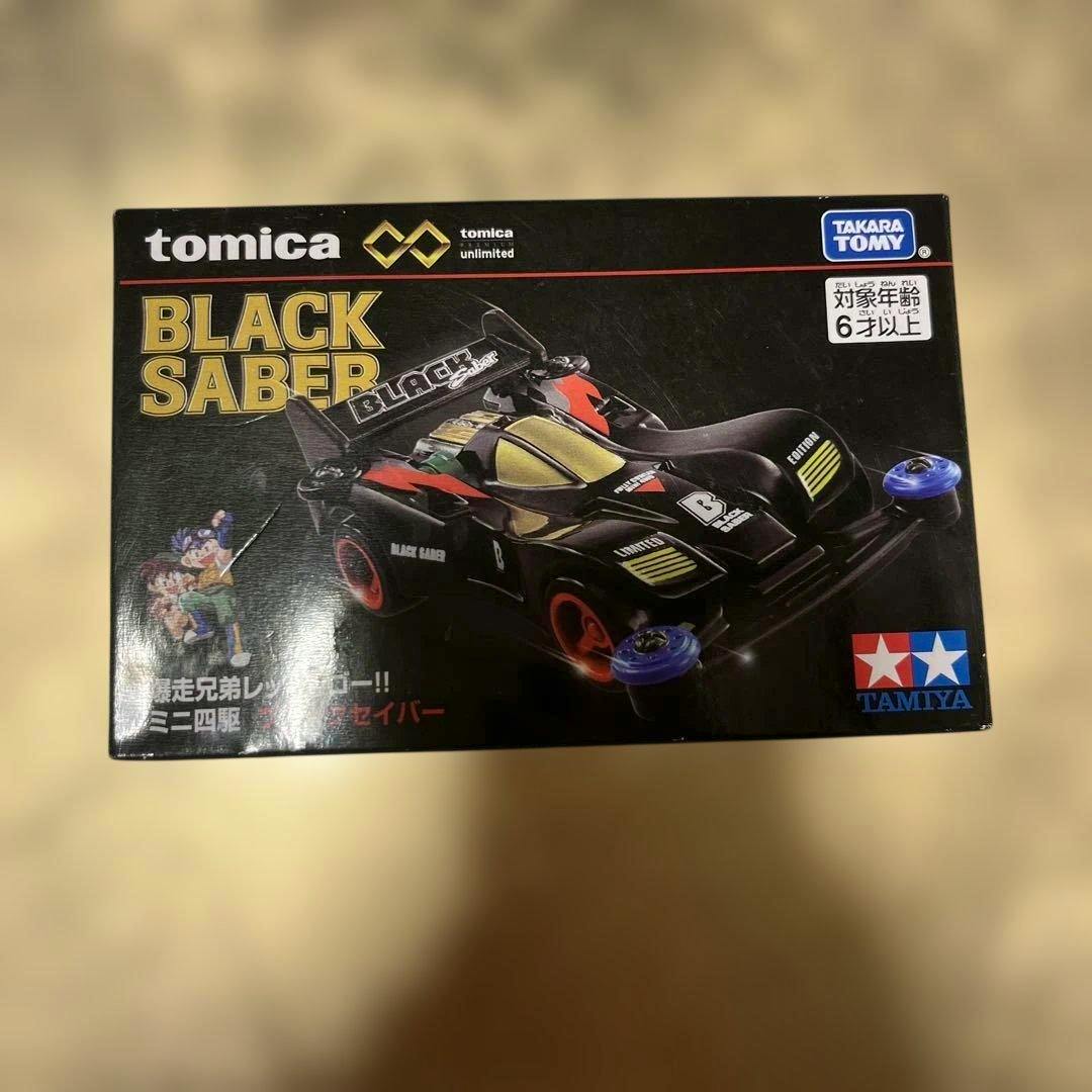 Front of the boxed Tomica Premium Unlimited "Black Saber" mini 4WD toy showing the car artwork and branding.