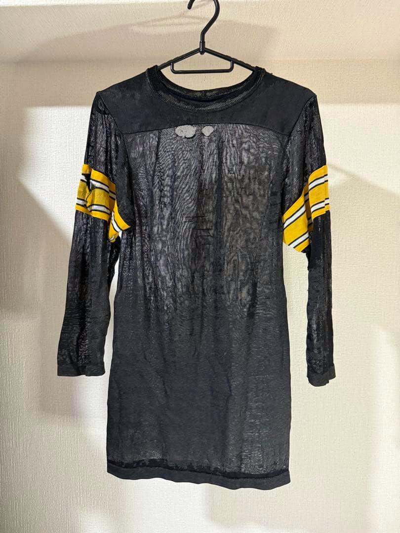 Black sheer vintage Rawlings NFL long-sleeve football jersey with yellow-striped sleeve bands hanging on a hanger.