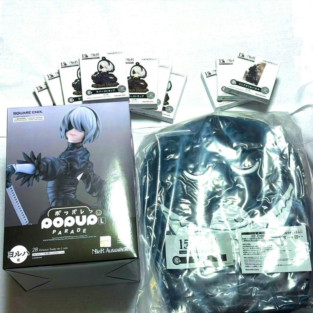Photo showing a boxed Pop Up Parade 2B figure, several small boxed NieR Yorha prizes, and a sealed plastic bag on a white background.